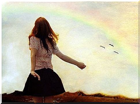 Woman on the meadow and rainbow